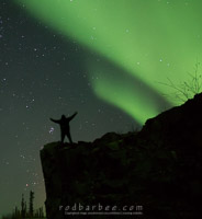 figure silhouetted with aurora