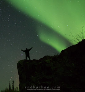 silhouetted figure and aurora
